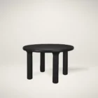 Round black solid wood accent table with chunky legs and sculptural design – Mercana Soma Table.