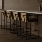 Black leather and metal frame bar stool with minimalist silhouette and slim profile.