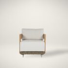 Outdoor lounge chair with white cushions, woven wicker frame, and teak wood arms.