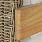 Outdoor lounge chair with white cushions, woven wicker frame, and teak wood arms.