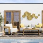 Outdoor lounge chair with white cushions, woven wicker frame, and teak wood arms.