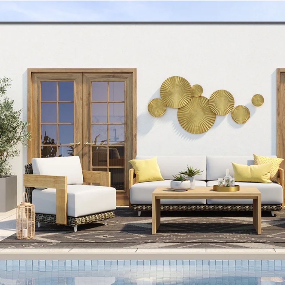 Outdoor lounge chair with white cushions, woven wicker frame, and teak wood arms.