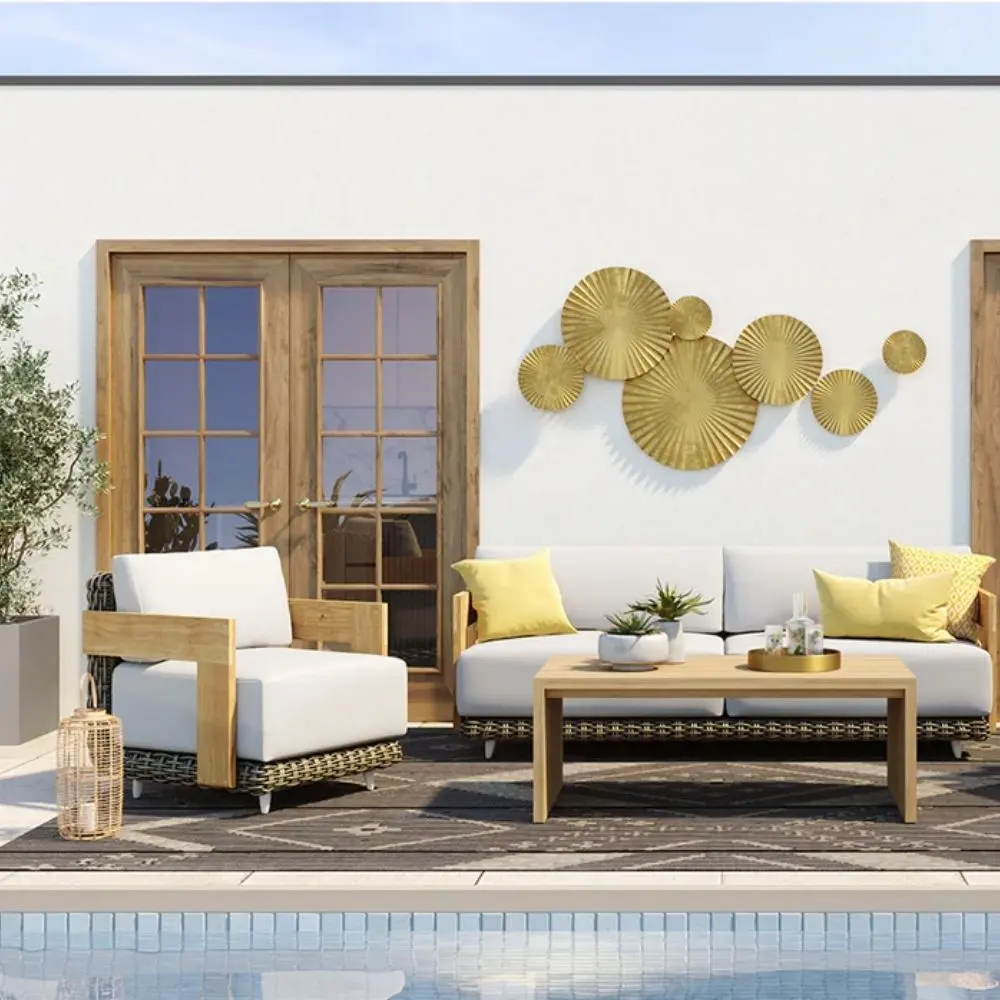 Outdoor lounge chair with white cushions, woven wicker frame, and teak wood arms.
