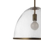 Glass dome pendant light with antique brass accents and exposed bulb, suspended by a matching brass chain.