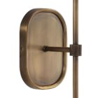 Brushed brass wall sconce with a white cylindrical fabric shade and elongated backplate.