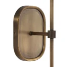 Brushed brass wall sconce with a white cylindrical fabric shade and elongated backplate.