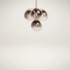 Sunpan Kamara Chandelier with four smoked glass globe shades and a brushed gold frame.