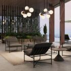 A modern lounge chair featuring a slim black metal frame and deep charcoal grey cushioned seat and backrest.