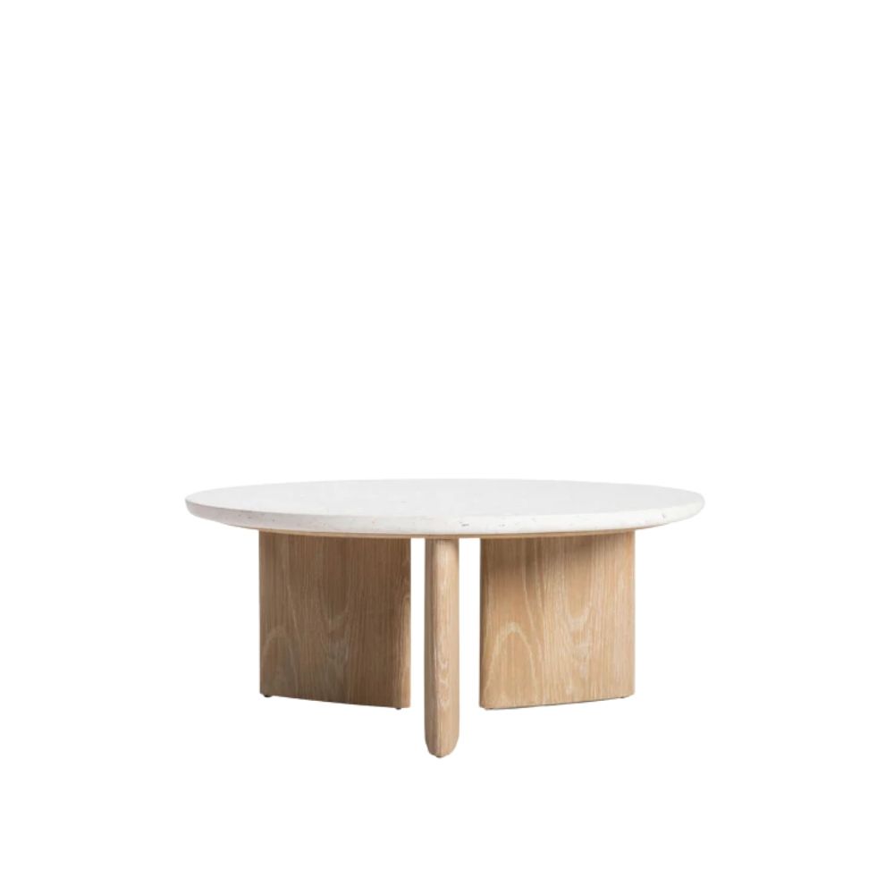 Round coffee table with a white stone top and sculptural blonde wood base in an intersecting design.