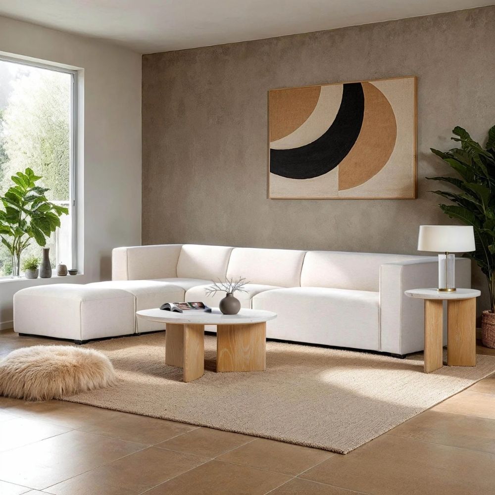 Round coffee table with a white stone top and sculptural blonde wood base in an intersecting design.