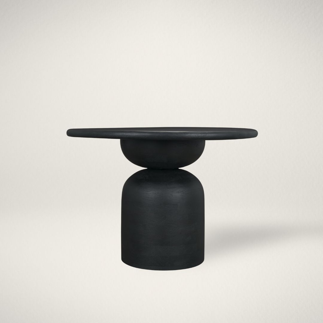 MC ATLAS DINING TABLE Modern round black dining table with sculptural pedestal base and smooth wood finish.