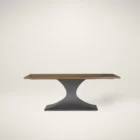 Rectangular wood dining table with a sculptural black pedestal base and rustic finish.