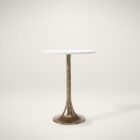 A round side table with a smooth white marble top and antique brass pedestal base, featuring a modern yet timeless silhouette.
