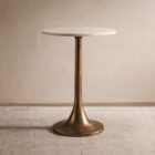 A round side table with a smooth white marble top and antique brass pedestal base, featuring a modern yet timeless silhouette.
