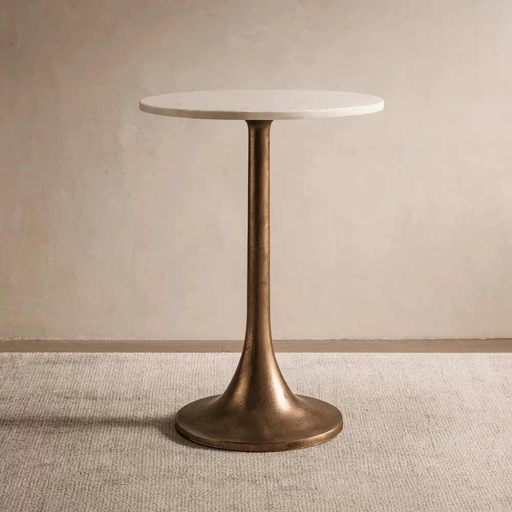 A round side table with a smooth white marble top and antique brass pedestal base, featuring a modern yet timeless silhouette.
