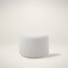 Renwil Audrina Ottoman with round silhouette upholstered in soft white textured fabric.