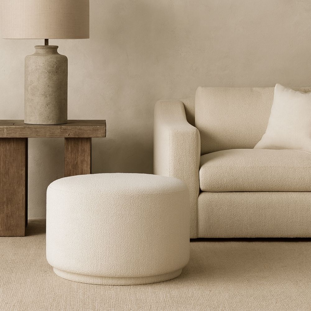 Renwil Audrina Ottoman with round silhouette upholstered in soft white textured fabric.