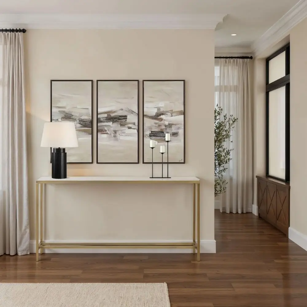 Slim console table with a white marble top and gold metal frame.