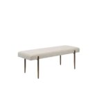 A minimalist upholstered bench in ivory boucle fabric with slim antique brass-finished tapered legs.