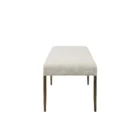 A minimalist upholstered bench in ivory boucle fabric with slim antique brass-finished tapered legs.