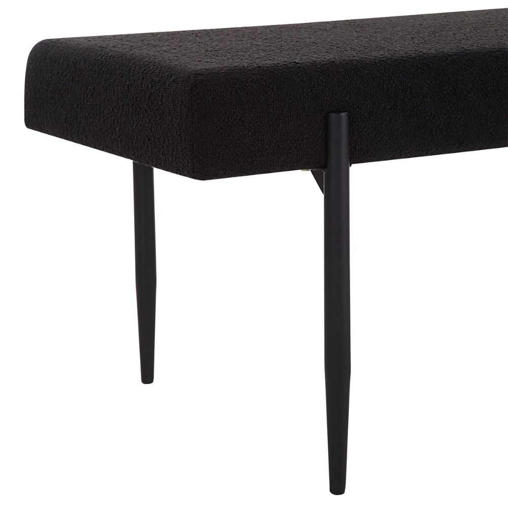 Modern black upholstered bench with slim tapered legs.