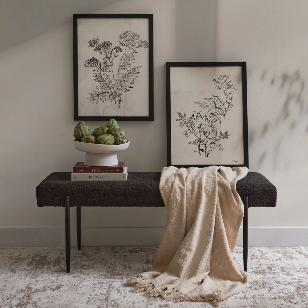 Modern black upholstered bench with slim tapered legs.