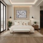 A modern upholstered bench with a slim ivory cushion and sleek antique brass-finished metal frame with tapered legs