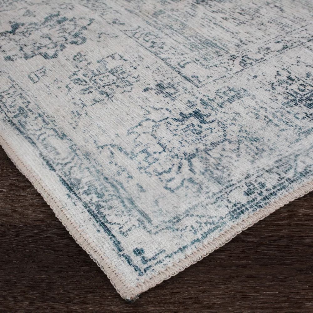 Light blue and ivory distressed rug with vintage-inspired medallion and border design.
