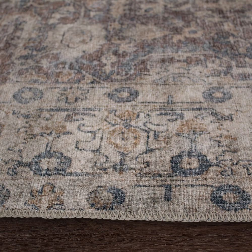 Vintage-inspired rug in muted brown, taupe, and soft blue with ornate medallion and border design.