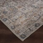 Vintage-inspired rug in muted brown, taupe, and soft blue with ornate medallion and border design.