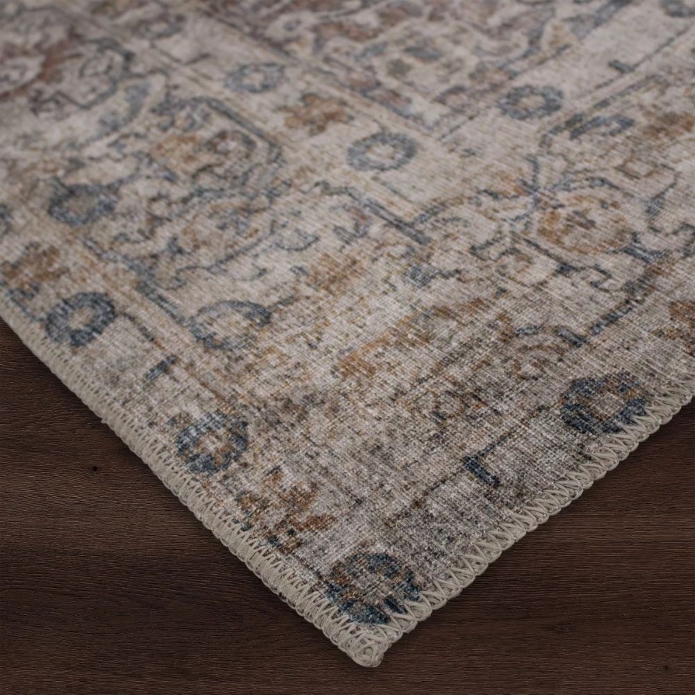 Vintage-inspired rug in muted brown, taupe, and soft blue with ornate medallion and border design.