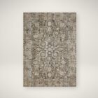 Distressed vintage rug in earthy taupe, beige, and soft grey with ornate medallion and border pattern.