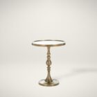 A round brass side table with a sculpted pedestal base and raised edge, featuring an antique finish and elegant silhouette.