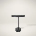 A modern black side table with a round top, slim central support, and cylindrical base in a minimalist design.