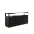 A modern black six-drawer dresser with slim brass handles, open top shelf, and a brass base accent.