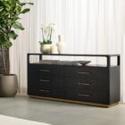 A modern black six-drawer dresser with slim brass handles, open top shelf, and a brass base accent.