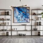 Tall narrow bookcase with slim gold metal frame and staggered open shelving.