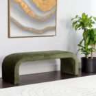 Modern curved green upholstered bench with seamless silhouette and low profile design.