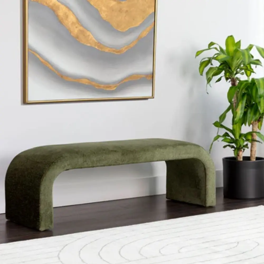 Modern curved green upholstered bench with seamless silhouette and low profile design.
