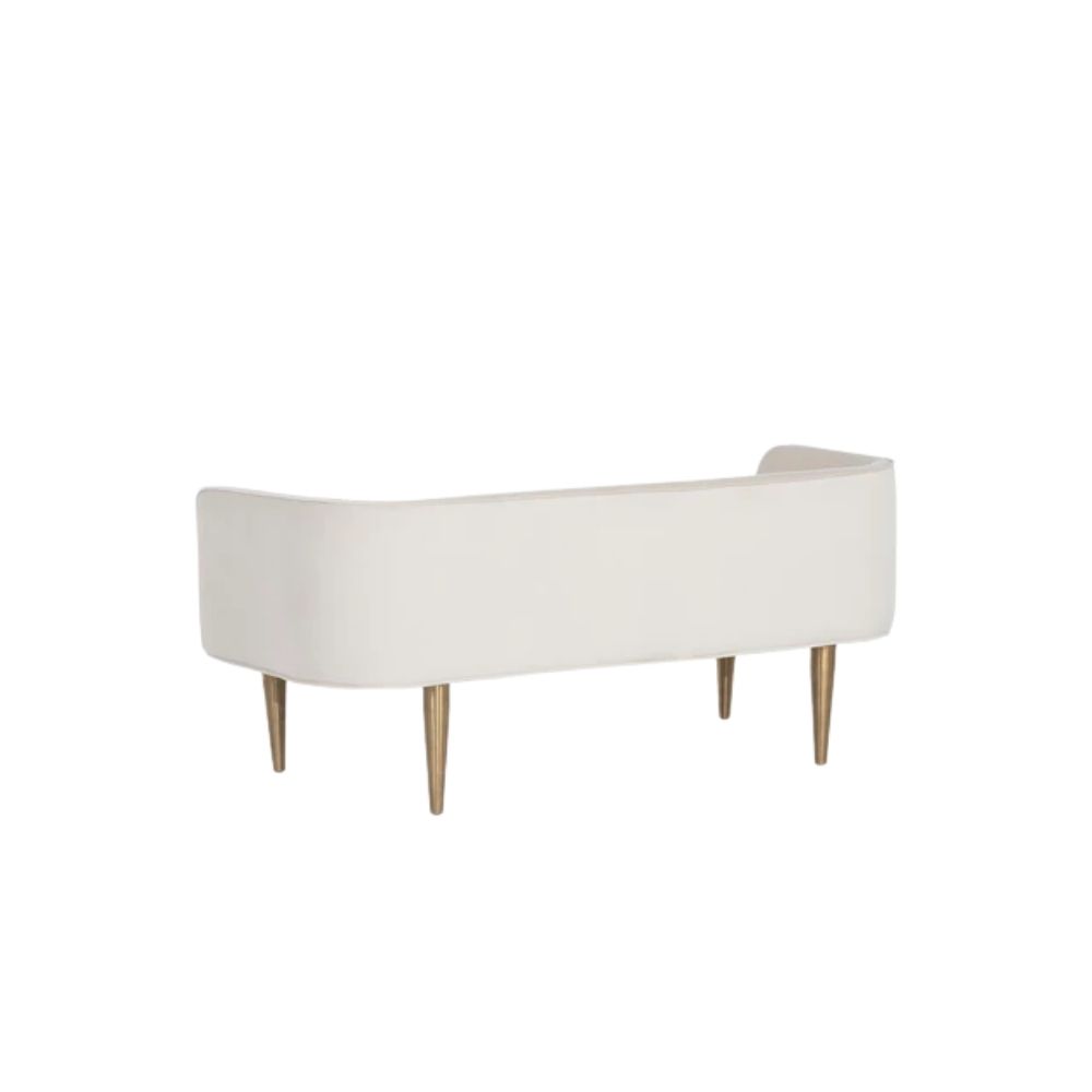 White upholstered bench with slim curved backrest and tapered gold-finished legs.