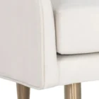 White upholstered bench with slim curved backrest and tapered gold-finished legs.
