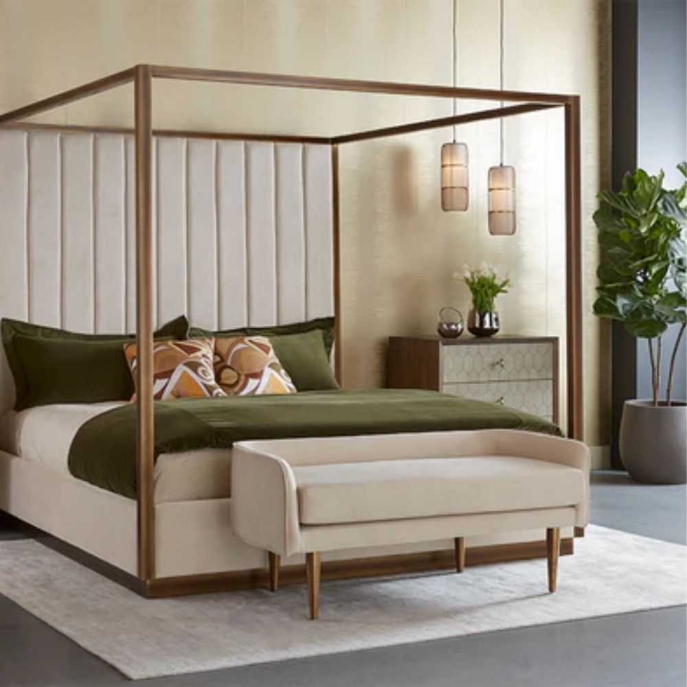 White upholstered bench with slim curved backrest and tapered gold-finished legs.