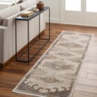 Traditional-inspired rug in muted shades of taupe, grey, and gold with a distressed medallion pattern.