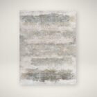 Modern distressed rug in layered blue, taupe, and grey tones with an abstract weathered finish.