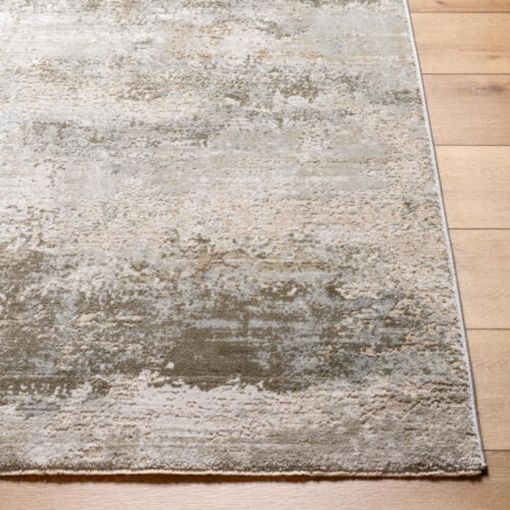 Modern distressed rug in layered blue, taupe, and grey tones with an abstract weathered finish.