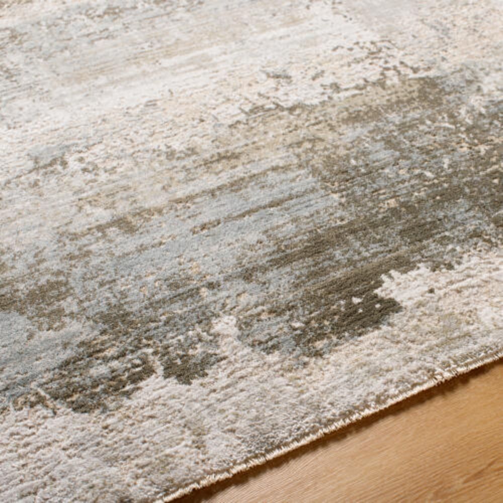 Modern distressed rug in layered blue, taupe, and grey tones with an abstract weathered finish.