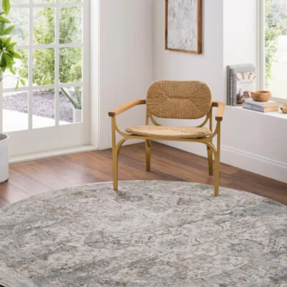 Traditional area rug with a distressed medallion pattern in soft grey, ivory, and muted blue tones.