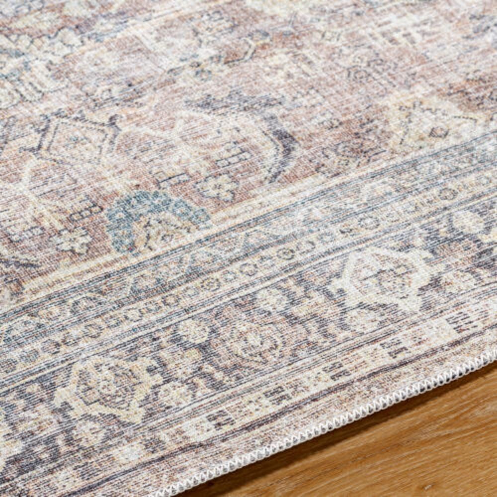 Vintage-inspired rug with a soft distressed pattern in blush, cream, and hints of blue with a classic border.
