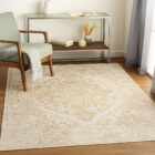 Beige and ivory machine woven rug with a soft medallion and distressed traditional pattern.