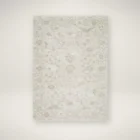 Neutral traditional rug in soft beige and cream with an all-over floral pattern and subtle distressed detailing.
